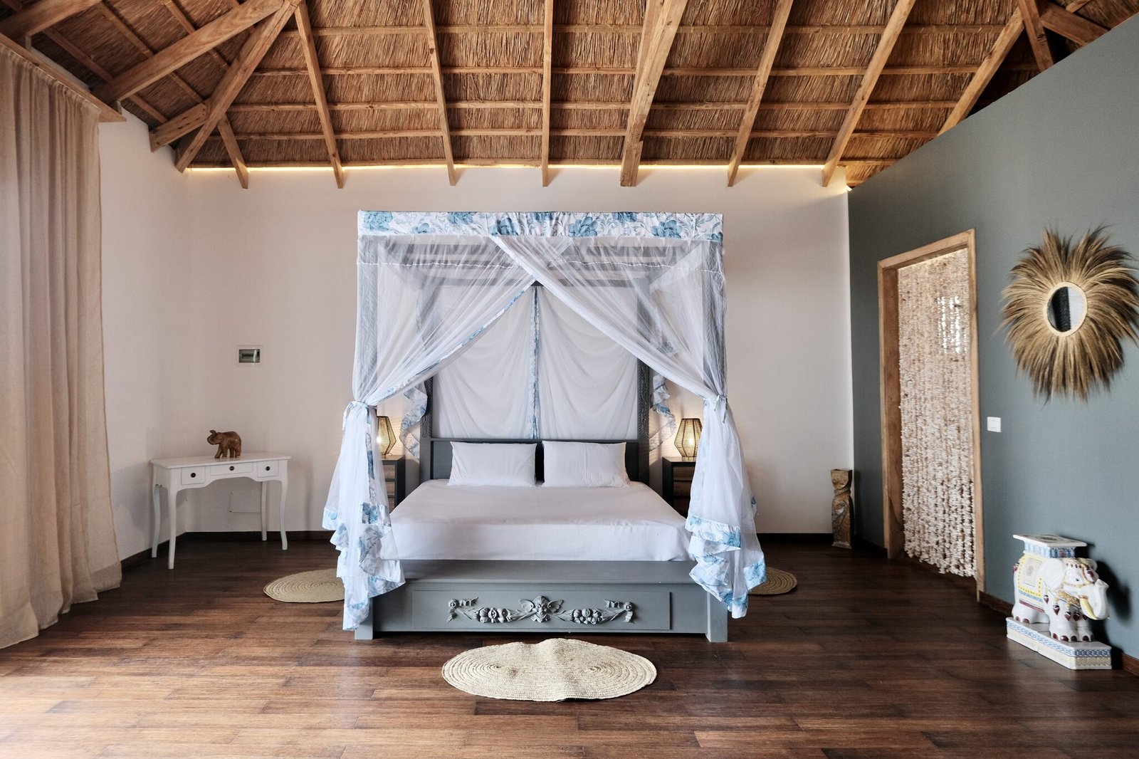 Luxury Villa bedroom with four-poster bed under a thatched roof