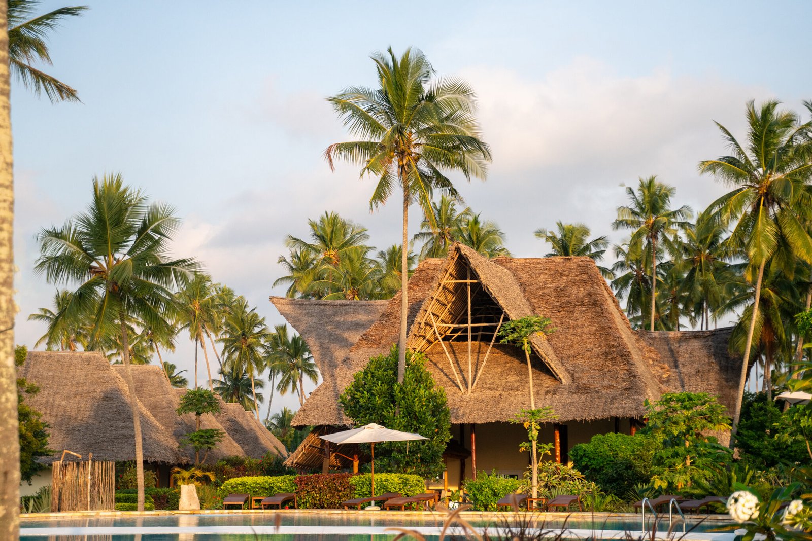 Pool and thatched roofs at sunset