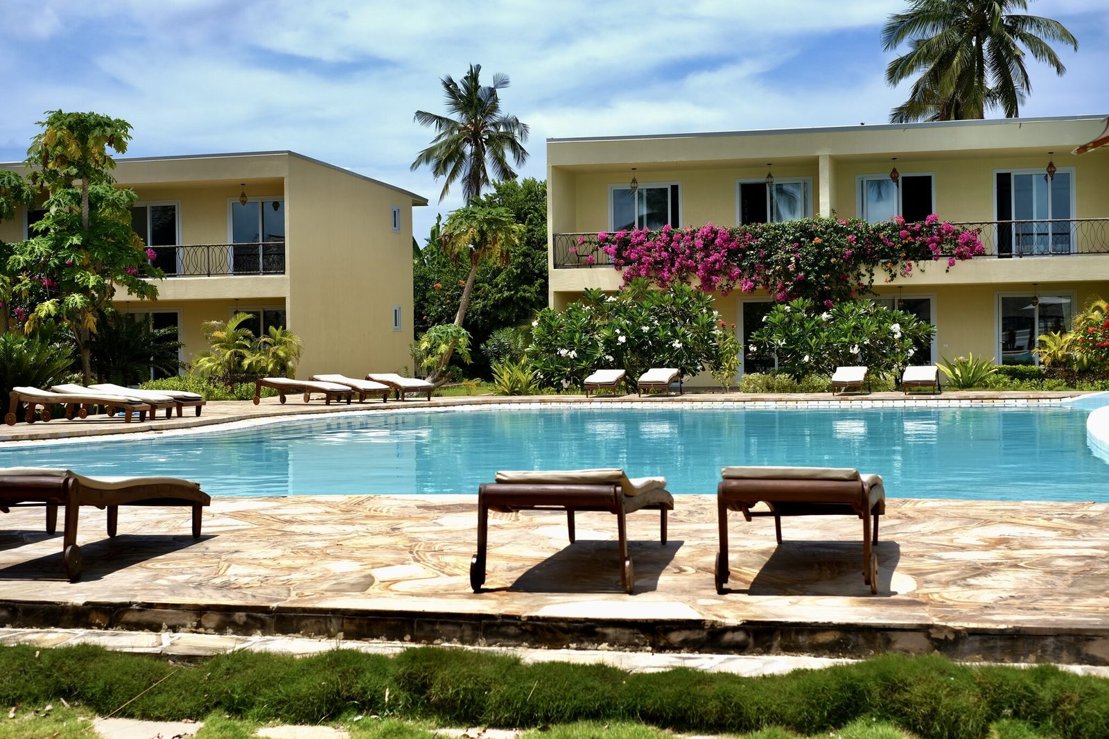 Resort pool with villas and sun loungers
